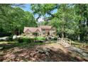 Beautiful home with a bridge and landscaping, surrounded by lush trees on a sunny day at 4853 Carlene Sw Way, Lilburn, GA 30047