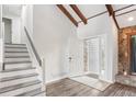 Bright entryway featuring vaulted ceilings with exposed beams, modern floors, and stairs to the upper level at 6249 Townsend Way, Riverdale, GA 30296