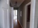 Hallway with hardwood floors, leading to rooms with neutral carpet and a bathroom on the right at 1378 Lucile Sw Ave, Atlanta, GA 30310