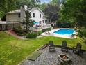 Expansive backyard features a swimming pool, fire pit and outdoor seating, all set within a lush, green landscape at 215 Ansley Ct, Roswell, GA 30076