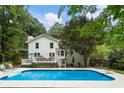 An inviting backyard oasis features a large swimming pool with deck, and a well-maintained lawn for outdoor enjoyment at 215 Ansley Ct, Roswell, GA 30076