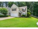 Inviting two-story home featuring a lush green lawn and mature trees at 496 Bottesford Nw Dr, Kennesaw, GA 30144
