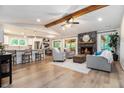 Open-concept living room with a stone fireplace, wood beam, and seamless flow to the kitchen at 195 Ansley Ct, Roswell, GA 30076