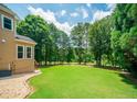A lush green lawn bordered by trees and shrubbery is visible from the side of the home at 2521 Wood Creek Ct, Dacula, GA 30019