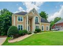 Charming two-story home with manicured lawn, columns at the entrance, and a welcoming, classic facade at 2521 Wood Creek Ct, Dacula, GA 30019