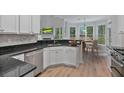 Modern kitchen with granite countertops, stainless steel appliances, and large windows for natural light at 2934 Mill Grove Ter, Dacula, GA 30019