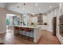 Spacious kitchen with an island, pendant lighting, white cabinetry and stainless steel appliances at 904 Urban Ash Ct, Johns Creek, GA 30022