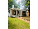 This home features updated landscaping, fresh green lawn, and beautiful white brick exterior with charming wood design accents at 1460 Hartford Sw Ave, Atlanta, GA 30310