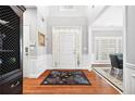 Inviting foyer with hardwood floors, wainscoting, neutral walls and a view into the dining room at 13995 Mariners Cv, Alpharetta, GA 30005
