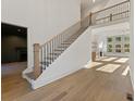Bright foyer featuring a staircase with metal balusters, hardwood floors, and natural light from large windows at 2410 Glade Overlook, Cumming, GA 30041