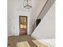 Grand foyer featuring a wooden door with glass, hardwood floors, and designer light fixture at 2410 Glade Overlook, Cumming, GA 30041