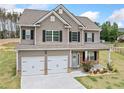 Beautiful two-story home with a well-manicured lawn, inviting front porch, and attached two-car garage at 31 Village Trce, Rydal, GA 30171