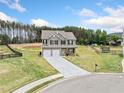 Expansive view of a two-story home with a long driveway and surrounding green landscape at 31 Village Trce, Rydal, GA 30171