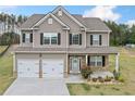 Charming two-story home boasts a welcoming porch, two-car garage, and beautiful curb appeal at 31 Village Trce, Rydal, GA 30171