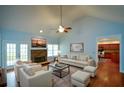 Light-filled living room features vaulted ceiling, stone fireplace, and hardwood floors overlooking the backyard at 6865 Cowan Mill Rd, Winston, GA 30187