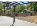 View of a backyard with concrete pad and a fire pit with perimeter seating. A wooden fence defines the yard at 2638 Lake Manor Cir, Duluth, GA 30096