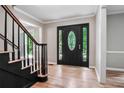Foyer with hardwood floors, staircase, black door, and decorative glass inserts at 2771 Kenwood Dr, Duluth, GA 30096