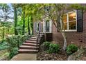 Brick home entrance featuring a decorative door, black shutters, and landscaped walkway at 2771 Kenwood Dr, Duluth, GA 30096