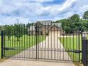 View of the gated driveway leading to the home with large lawn at 3905 Pointer Rd, Loganville, GA 30052