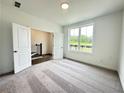Bright bedroom with neutral carpet, a large window overlooking the yard and an open door at 500 Healy Dr # 77, Cumming, GA 30040