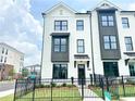 Modern townhome with white brick facade, black window trim, and manicured landscaping at 500 Healy Dr # 77, Cumming, GA 30040