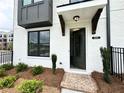 Charming entryway with a covered porch, brick walkway, and stylish front door at 500 Healy Dr # 77, Cumming, GA 30040