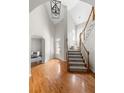 Grand foyer with hardwood floors, a staircase, and soaring ceilings with modern light fixture at 1560 Heritage Trl, Roswell, GA 30075