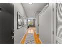 Hallway with hardwood floors and gray walls featuring modern decor and leading to the living space at 800 Peachtree Ne St # 8612, Atlanta, GA 30308
