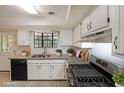 Well-lit kitchen with white cabinets, stainless appliances, and garden window at 3087 Drexel Ln, Jonesboro, GA 30236