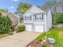 Two-story home boasts an attached garage, blue siding, and a well-manicured lawn at 1452 Evanston Ln, Marietta, GA 30062