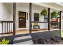 Inviting front porch with dark wood accents, hanging plants, and a cozy bench at 2090 Rocky Mill Drive, Lawrenceville, GA 30044