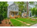 Charming two-story home with covered front porch, landscaped yard, and sidewalk at 38 Mildred Nw Pl, Atlanta, GA 30318