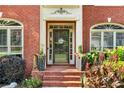 Close-up of the front entrance with decorative plants and brick steps, creating an inviting approach at 660 Briarleigh Way, Woodstock, GA 30189