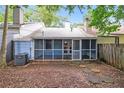 Backyard featuring a screened-in porch, mature trees and landscaping at 937 Ohara Drive Dr, Jonesboro, GA 30236