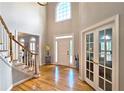 Bright foyer featuring a grand staircase, gleaming hardwood floors, and a high ceiling with a large window at 1620 Silverleaf Way, Alpharetta, GA 30005