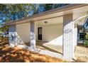 View of covered outdoor patio with concrete floors and white brick columns that accent the home at 409 Colette Ln, Social Circle, GA 30025