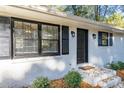 Close up of the home's front door with black shutters and landscaping around the front entrance at 409 Colette Ln, Social Circle, GA 30025