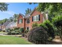 Beautiful brick home with lush landscaping and a well-maintained lawn on a sunny day at 1884 Whitehawk Ct, Lawrenceville, GA 30043