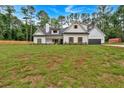 Charming two-story white farmhouse with black trim and wood shutters surrounded by a huge green lawn at 3088 Hiram Sudie Road, Hiram, GA 30141