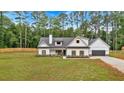Picturesque white farmhouse with dark shutters, an attached garage, and a spacious green lawn at 3088 Hiram Sudie Road, Hiram, GA 30141