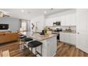 Kitchen island flows into living area with stainless appliances, granite counters, and barstool seating at 1911 Colestock Se Ave, Conyers, GA 30094