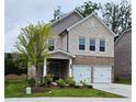 Charming two-story home featuring a stone facade, brick accents, a cozy front porch, and a two-car garage at 1961 Ecoland Dr, Grayson, GA 30017
