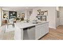 Modern kitchen with stainless dishwasher and sink, open concept to the living room with hardwood floors at 8502 Polston Lot 144 Pl, Douglasville, GA 30134