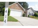 View of the stone-accented home with a two-car garage, seen from the street at 414 Norton Xing, Woodstock, GA 30188