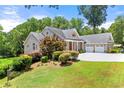 Lovely brick home with attached two-car garage and meticulously maintained landscaping with bright green lawn at 4829 Moon Rd, Powder Springs, GA 30127
