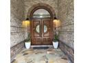 Elegant front entryway with a custom wood double door and stone accents at 4829 Moon Rd, Powder Springs, GA 30127