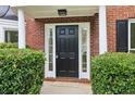 Inviting front door with sidelights, white trim, and manicured bushes at 9744 Spyglass Dr, Villa Rica, GA 30180