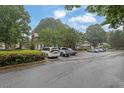 Large parking lot with multiple parked cars and green trees providing a quiet atmosphere at 1066 Wedgewood Ln, Tucker, GA 30084