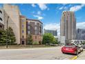 Building exterior view emphasizing architectural style, streetscape, and nearby high-rise buildings against a blue sky at 390 17Th Nw St # 6055, Atlanta, GA 30363