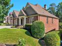 Charming brick home with a well-maintained lawn and lush landscaping at 4050 Bonnett Creek Ln, Hoschton, GA 30548